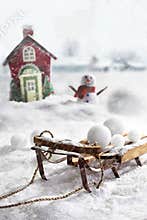 Wooden sled and snowballs with wintery background