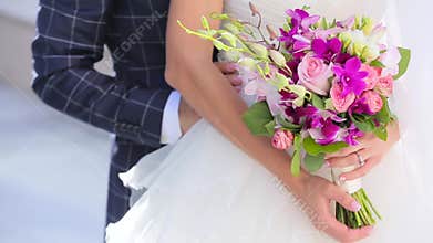 The bridegroom embraces the bride with flowers