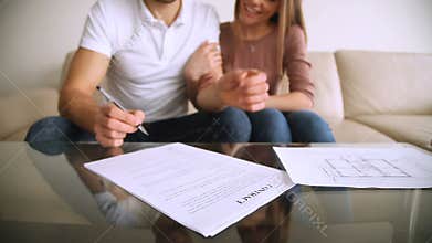 Happy young couple signing contract agreement and hugging, mortgage investment