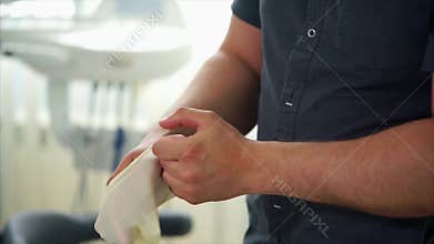 Medical doctor cleaning his hand with cleaning liquid and putting in gloves.