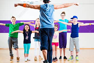 Dance teacher giving kids Zumba fitness class