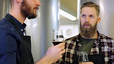 Men with drinking and testing beer at brewery