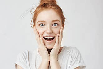 Close up portrait of surprised happy freckled redhead girl