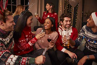 Friends In Festive Jumpers Celebrate At Christmas Party