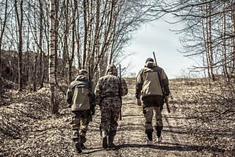 Group of men hunters going up on rural road during hunting season