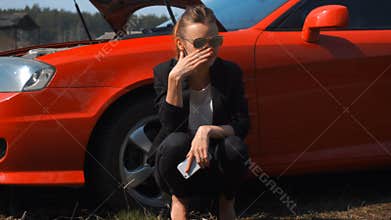 Sad girl near red broken car