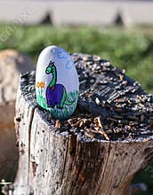 Painted rock with cute dinosaur