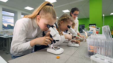 The steadicam shooting of the girl adjusting the microscope. 4K.