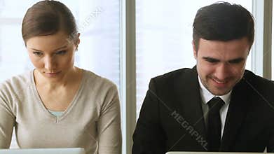 Curious woman spying male colleague, looking at his laptop screen