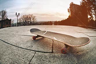 Skateboard close-up shot at wide angle on sunset light