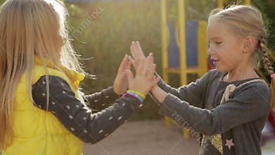 Two little girls preschoolers fooling around and playing patty-cake