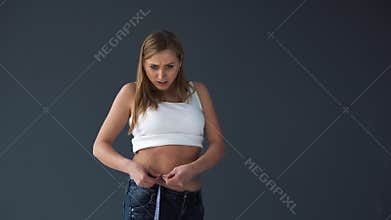 Overweight Female woman measuring her waist with a measuring tape. She was disappointed at her complete figure
