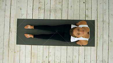 Beautiful young woman working out indoors, doing yoga exercise in the room, downward facing dog pose, adho mukha