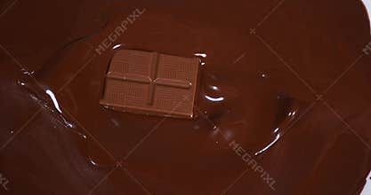 Chocolate tablet falling into milk chocolate