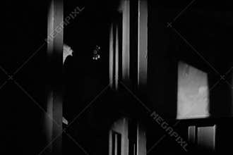 Man walking into phone booth at night