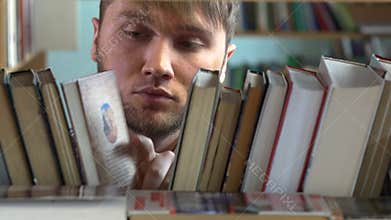 Young man browsing through the racks of books in a