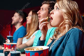 Excited woman with popcorn in cinema