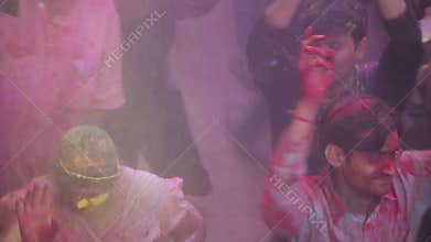 Barsana, Mathura District, Uttar Pradesh, India - 03/25/2013 - Pan shot of people celebrating and dancing in colorful Holi festive