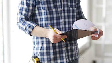 Close up of man looking and writing to clipboard