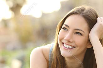 Woman with white teeth thinking and looking sideways