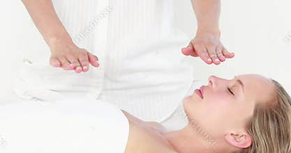 Calm woman receiving reiki treatment