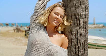 Woman with Wind Swept Hair Next to Tree on Beach