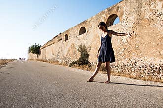 Young model wearing sunglasses and summer clothes dancing
