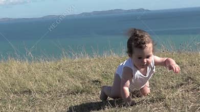 Baby girl crawling outdoors.
