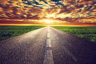Long straight road, way towards sunset sun