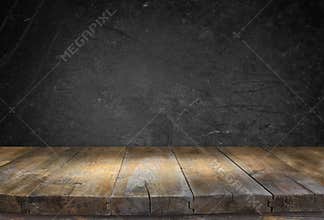 Grunge vintage wooden board table in front of black textured background