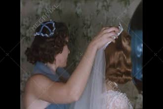 Bridesmaid helping bride with wedding veil