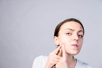 Young Woman Pricking Blackheads on her Cheek