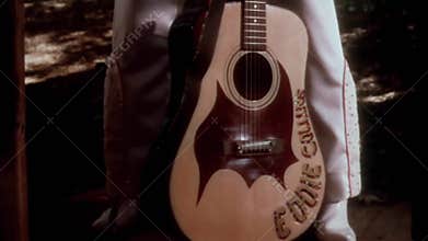 Tilt up shot of Elvis impersonator with guitar