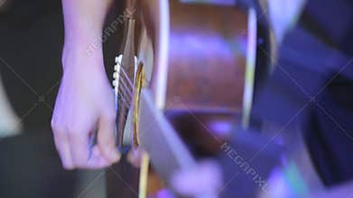 Close-up of the man playing the quitar in the
