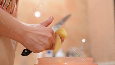 Hands cutting potatoes into slices