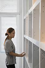 Woman by bookshelf