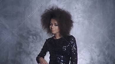Young beautiful african girl posing in elegant dress, looking at camera.