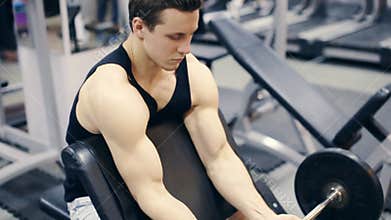 Man working arms at gym, he lifting bells and working his biceps, slow motion