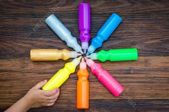 Bottles with colorful dry pigments on wooden background
