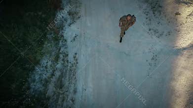 Certain military man walk on the sandy road