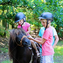 Kids having fun at horse riding summer camp
