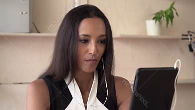 Woman using app on touch screen tablet for video call.