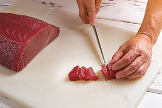Hand with knife cuts meat.