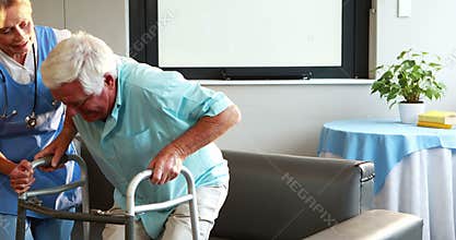 Nurse helping retired man with walker