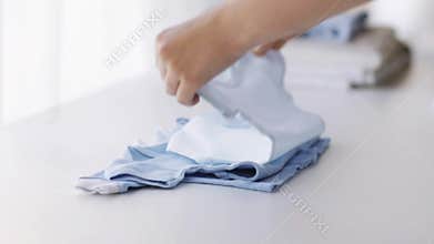 Woman hands folding baby boys clothes at home 12
