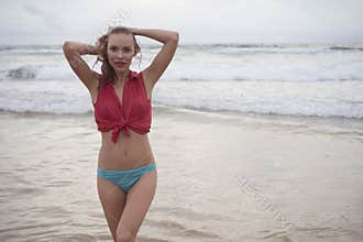Sensual woman wearing shirt and bikini bottom on a beautiful summer day at the beach.