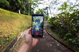 Hand holding a cellphone playing Pokemon Go