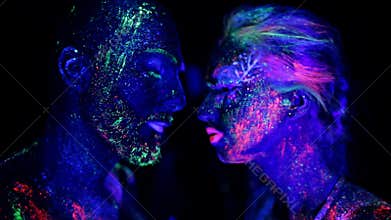 Passion couple in love painted fluorescent powder under ultraviolet light.