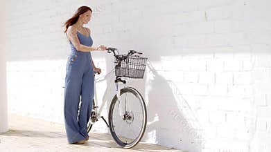 Elegant young woman holding a bicycle