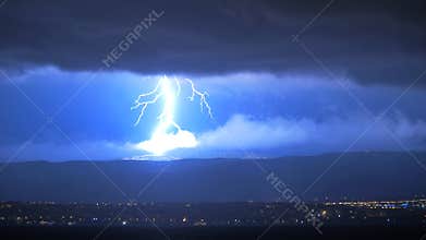 Lightening Striking Hills Above Town at Night